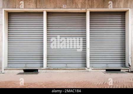 Un gros plan de trois vieux shatters en métal d'une entrée dans les rues Banque D'Images