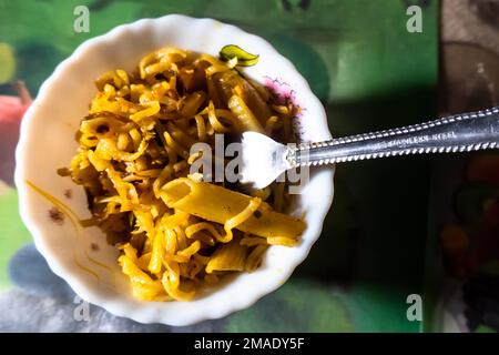 Nouilles avec cuillère dans un bol blanc. Nouilles asiatiques instantanées épicées avec pâtes. Banque D'Images