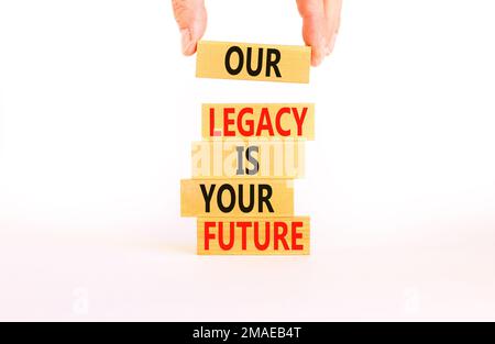 Symbole de l'héritage et du futur. Concept Words notre héritage est votre avenir sur des blocs de bois. Magnifique table blanche fond blanc. Main d'homme d'affaires. Entreprise Banque D'Images