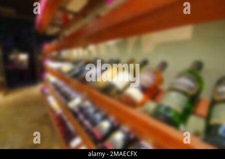 Magasin de vins flous allée porte-bouteilles de champagne whisky allongé sur des étagères en bois Banque D'Images