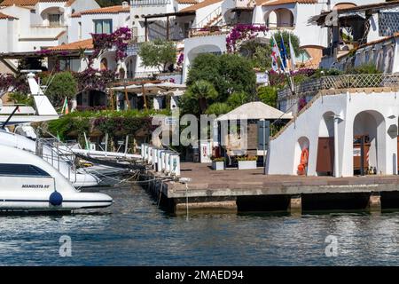 Marina dell' Orso di Poltu Quatu Waterfront. Vue sur le quai de l'hôtel et du restaurant avec l'artisanat amarré et l'eau calme. Sardaigne, Italie. Banque D'Images