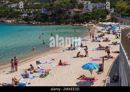 Vue sur la vie de la plage méditerranéenne et colorée à la plage de Cala Batistoni, en Sardaigne, avec des personnes appréciant cet emplacement au bord de la mer au soleil chaud; Banque D'Images