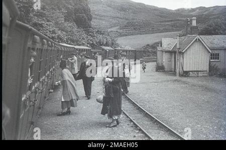 Un train à la gare de Tan-y-Bwlch sur le chemin de fer Ffestinog en 1930s avec la gare de prendre le feu Bessie Jones en costume traditionnel gallois Banque D'Images