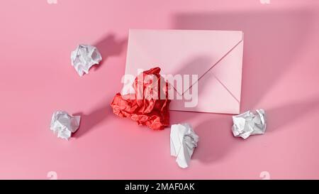 Coeur de papier et feuilles de papier froissés pour écrire avec une enveloppe artisanale.feuille de papier froissé en forme de coeur sur fond rose. Valen Banque D'Images