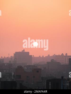 Soleil levant sur les bâtiments de Gizeh, le Caire, Egypte. Banque D'Images