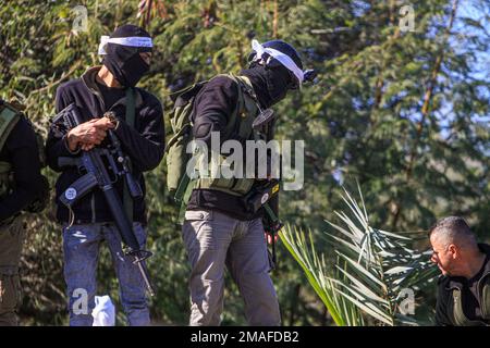 Jenin, Moyen-Orient. 19th janvier 2023. Des hommes armés palestiniens participent à la cérémonie funéraire des deux Palestiniens, Adham Jabareen, 28 ans, et Jawad Bawaqneh, 57 ans, Qui ont été tués par des balles de l'armée israélienne lors d'un raid dans le camp de réfugiés de Jénine, en Cisjordanie occupée. Des témoins oculaires ont déclaré que Jabareen avait été tué par balle par l'armée israélienne lors d'affrontements avec des armes à feu, et l'enseignant de l'école Bawaqnah a essayé de lui fournir les premiers soins après qu'il soit tombé au sol. Au cours de sa tentative de l'aider, un sniper israélien l'a tiré et, après cela, les forces israéliennes ont empêché les ambulances et les médecins Banque D'Images