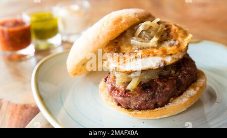 Authentique hamburger américain de qualité supérieure avec fromage de chèvre grillé. Banque D'Images