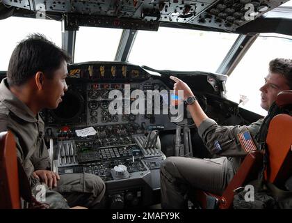 060808-N-4205W-001. [Complet] Légende de la scène : 060808-N-4205W-001 (le 8 août 2006)Royal Brunei Air Force (RBAF) CAPT. Dzulkiflee Shamsol (à gauche), écoute comme US Navy (USN) LT. CMDR. John Wigglesworth, affecté à l'escadron de patrouille 69 (VP-69), discute des caractéristiques du poste de pilotage d'aéronef P-3C Orion, pendant la phase Brunei de la coopération, préparation et formation (CARAT) 2006. Les techniques de surveillance maritime sont l'une des nombreuses compétences partagées au COURS DU CARAT, une série annuelle d'exercices bilatéraux de formation maritime entre les États-Unis et six nations d'Asie du Sud-est conçus pour établir des relations et Banque D'Images