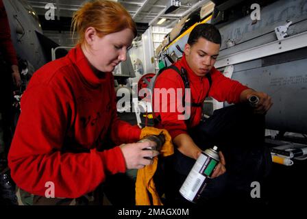 070128-N-2659P-121. [Complete] Légende de la scène : U.S. L'AVIATEUR Juan Ovales (à droite) remet des outils à l'aviateur de classe 3rd Katherine Gutherie (à gauche) lorsqu'ils effectuent la maintenance d'un pied d'injection de crémaillère de bombe, pour un escadron de guerre électronique tactique 138 (VAQ-138,'Yellowjaks') EA-6B Prowler Dans la baie hangar, à bord du porte-avions de la classe Nimitz USS JOHN C. STENNIS (CVN 74) le 28 janvier 2007, tandis que les STENNIS et Carrier Air Wing 9 (CVW-9) effectuent des qualifications de transporteur de la côte du sud de la Californie avant la transittine Banque D'Images