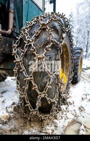 Gros plan sur une roue 4x4 tout-terrain extrêmement grosse équipée de chaînes à neige et à boue. Véhicule 4x4 tout-terrain extrême avec chaînes à neige et à boue sur roues utilisées Banque D'Images