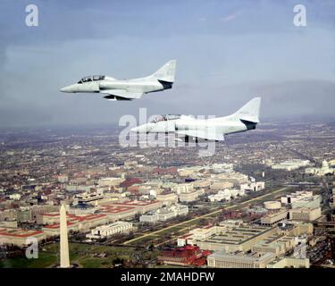 Vue aérienne à gauche de deux avions Skyhawk de l'Escadron composite de la flotte 12 (VC-12) TA-4J en formation au-dessus de la ville. Base: Washington État: District de Columbia (DC) pays: Etats-Unis d'Amérique (USA) Banque D'Images