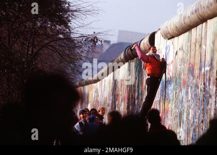 Un homme d'Allemagne de l'Ouest utilise un marteau et un burin pour couper un morceau du mur de Berlin comme souvenir. Une partie du mur a déjà été démolie à la Potsdamer Platz. Base: Berlin pays: Allemagne / Allemagne (DEU) Banque D'Images