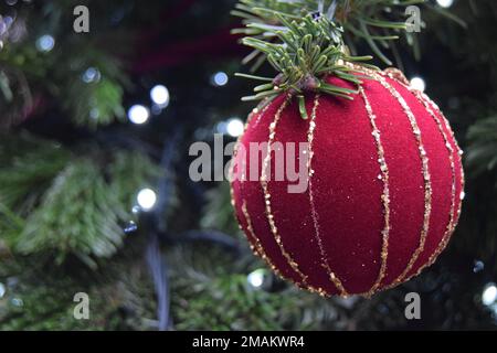 Une boule en velours rouge et or est suspendue à un sapin de Noël dans un cadre extérieur à Londres, en Angleterre, le 2022 novembre. Banque D'Images