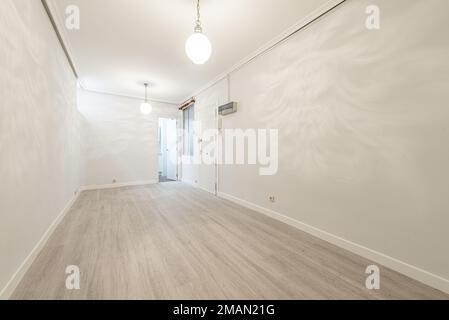 Salle de séjour et hall d'une maison vide avec plafonds avec moulures en plâtre et sols en bois clair Banque D'Images