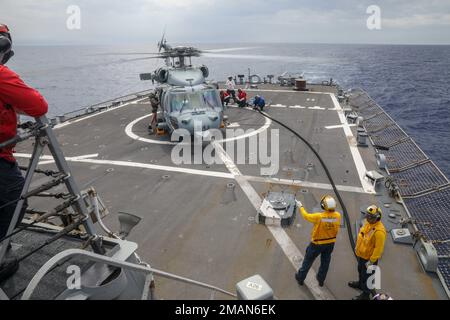 Les marins DE LA MER DES PHILIPPINES (31 mai 2022) à bord du destroyer de missile guidé de classe Arleigh Burke USS Benfold (DDG 65) ravitaillent un hélicoptère MH-60s Sea Hawk, affecté aux « faucons dorés » de l’escadron de combat en mer d’hélicoptère (HSC) 12, pendant les opérations de vol. Benfold est affecté au Commandant de la Force opérationnelle (CTF) 71/Destroyer Squadron (DESRON) 15, le plus grand DESRON déployé à l’avant de la Marine et la principale force de surface de la flotte américaine 7th. Banque D'Images