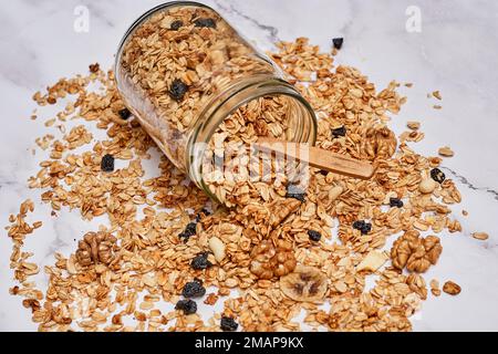 granos dans un pot en verre sur un comptoir en marbre recouvert de bleuets, d'amandes et de mûres Banque D'Images