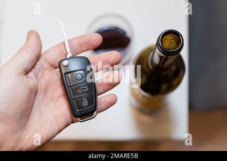 Clé de voiture et une bouteille de vin dans un fond - fond bleuté Banque D'Images