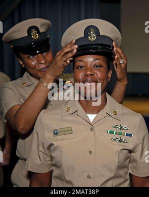 Makeisha Ervin, technicienne en chef des systèmes d'information, a sa couverture placée par la technicienne en chef principale des systèmes d'information, Arrie Copeland, lors de la cérémonie de mise en service de l'unité de prémise en service John F. Kennedy (CVN 79). Le grade de chef principal et de chef principal a été créé par 1 juin 1958, en vertu d'une modification à la Loi sur l'indemnisation des accidents de carrière de 1949. John F. Kennedy est le deuxième porte-avions de classe Ford et est en construction au chantier naval Huntington Ingalls Industries Newport News. Banque D'Images