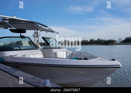 bateau pour les sports nautiques coincé à la jetée pendant la mi-journée avec le ciel bleu et un lac en arrière-plan, pas de personnes Banque D'Images