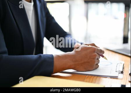 Un homme d'affaires asiatique sérieux et professionnel s'est bien serré, assis à la table de réunion avec un rapport financier d'affaires. image rognée Banque D'Images