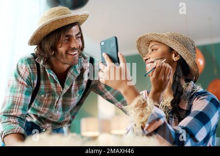 En voulez-vous aussi. un jeune couple parlant tout en appliquant le maquillage à la maison. Banque D'Images