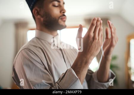 Cette relation est la prière. un jeune musulman priant dans le salon à la maison. Banque D'Images