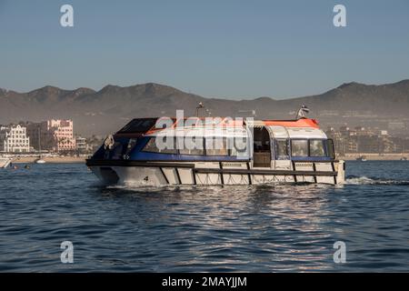 Un bateau de croisière se dirige vers le port de Cabo San Lucas, Mexique, depuis l'un des trois navires de croisière à l'ancre dans le port. Banque D'Images