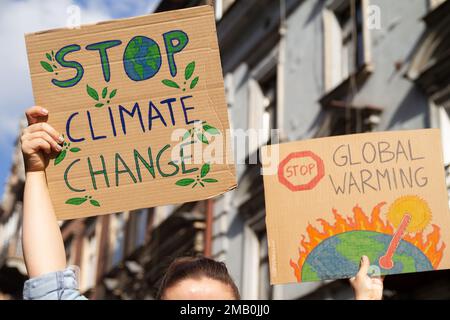 Les manifestants sont en signe d’arrêter le changement climatique et de mettre un terme au réchauffement climatique. Les gens avec des pancartes à la grève de manifestation de rassemblement de protestation. Banque D'Images