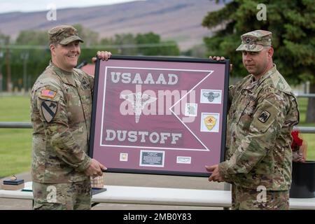 Le Maj. Jason West, commandant sortant des États-Unis Le détachement d'ambulance aérienne de l'Armée de terre Yakima, 2-158 Bataillon des hélicoptères d'assaut, 16th Brigade de l'aviation de combat reçoit un cadeau de ses soldats avant la cérémonie de changement de commandement du détachement au Centre d'entraînement de Yakima, Washington, le 9 juin 2022. Banque D'Images