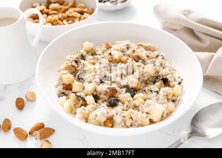 Bol à flocons d'avoine. Bouillie d'avoine aux noix, aux pommes, aux graines de chia et aux graines de citrouille pour un petit déjeuner ou un déjeuner sain. Alimentation végétalienne saine, régime alimentaire Banque D'Images