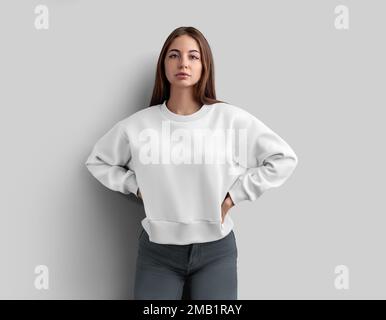 Cache blanc coupe-bas sweat-shirt sur une fille en jeans gris, pour le design, la marque, l'impression, la vue avant de chemise pour femmes. Modèle de vêtement, manches longues pour adve Banque D'Images