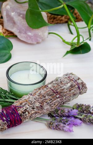 Bâton à taches de bougie et de lavande sur une table avec des plantes et des cristaux Banque D'Images