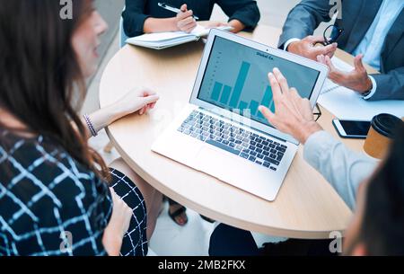 Prévision de leur succès. Gros plan d'un groupe de professionnels analysant des graphiques sur un ordinateur portable. Banque D'Images