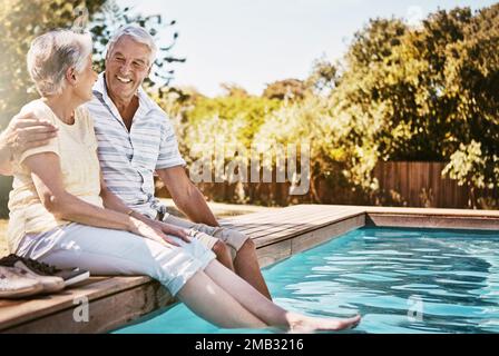 Couple senior, câlin et détendez-vous au bord de la piscine pour l'amour ou le temps de collage de qualité ensemble pendant les vacances d'été. Joyeux homme âgé tenant une femme se détendant Banque D'Images