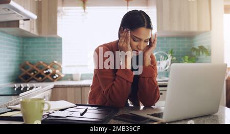 Regarder un écran d'abord dans la matinée. une jeune femme d'affaires souffrant d'un mal de tête en travaillant à la maison. Banque D'Images