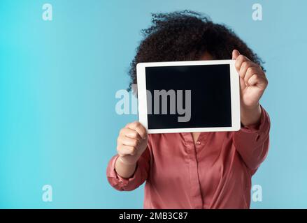 Regardez-moi, je suis sur le point de passer en direct. Photo en studio d'une jeune femme tenant une tablette numérique avec un écran vierge sur fond bleu. Banque D'Images
