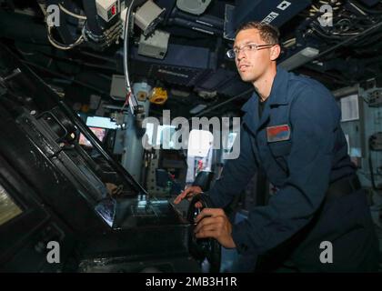 MER DES PHILIPPINES (10 juin 2022) le Matelot de Boatswain Patrick Seyler, de St. George, en Caroline du Sud, est à la barre de la pilothouse à bord du destroyer à missiles guidés de classe Arleigh Burke USS Benfold (DDG 65). Benfold est affecté au Commandant de la Force opérationnelle (CTF) 71/Destroyer Squadron (DESRON) 15, le plus grand DESRON déployé à l’avant de la Marine et la principale force de surface de la flotte américaine 7th. Banque D'Images