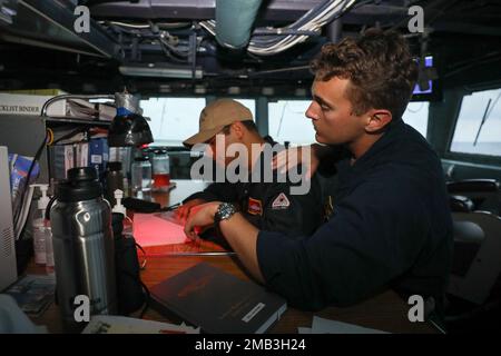 MER DES PHILIPPINES (10 juin 2022) Lt. j.g. William Watkins, de l'Université Lincoln, en Pennsylvanie, et Ensign Jerek Columna, de New York, créent un panneau de manœuvre dans le pilothouse à bord du destroyer à missiles guidés de classe Arleigh Burke USS Benfold (DDG 65). Benfold est affecté au Commandant de la Force opérationnelle (CTF) 71/Destroyer Squadron (DESRON) 15, le plus grand DESRON déployé à l’avant de la Marine et la principale force de surface de la flotte américaine 7th. Banque D'Images