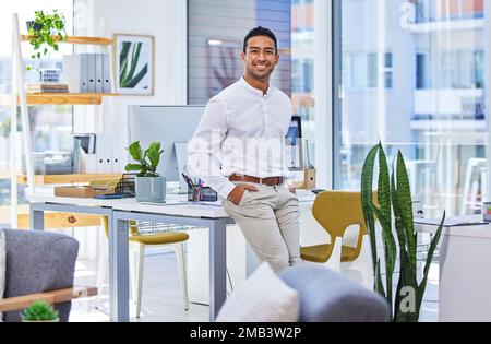 Il a une forte volonté de réussir et de surmonter les obstacles. un jeune homme d'affaires debout dans un bureau moderne. Banque D'Images