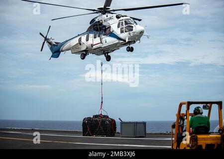 220611-N-DW158-1083 MER DES PHILIPPINES (11 juin 2022) Un hélicoptère Super Puma (EC-225) dépose des cargaisons du navire de ravitaillement de la flotte du Commandement militaire de Seallift USNS Amelia Earhart (T-AKE 6) sur le pont de vol des États-Unis Le seul porte-avions de la Marine USS Ronald Reagan (CVN 76), déployé à l’avant, au cours d’une reconstitution verticale. Ronald Reagan, le navire amiral du Carrier Strike Group 5, fournit une force prête à combattre qui protège et défend les États-Unis, et soutient les alliances, les partenariats et les intérêts maritimes collectifs dans la région Indo-Pacifique. Banque D'Images