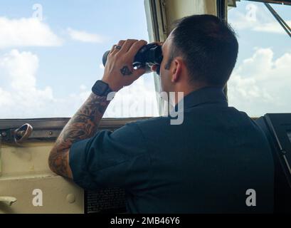 Port de l'APRA, Guam. (11 juin 2022) – le lieutenant Anthony Moretti, officier des opérations affecté à l'agent sous-marin de classe terrestre Emory S. USS Frank Cable (AS 40), observe les opérations maritimes et d'ancrage au moment où le navire quitte le port d'Apra, à Guam (11 juin 2022). Frank Cable part pour une patrouille afin de procéder à l'entretien et à la logistique expéditionnaires à l'appui de la sécurité nationale dans la zone d'opérations de la flotte américaine 7th. Banque D'Images