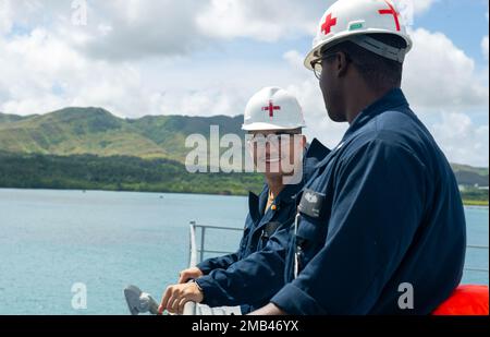 Port de l'APRA, Guam. (11 juin 2022) – l'hôpital Corpsman 3rd classe Anthony Sanchez, de Pennsylvanie, et l'hôpital Corpsman 3rd classe Quirinius White, du Mississippi, tous deux affectés à l'émory S. le sous-marin de classe terrestre USS Frank Cable (AS 40), sont debout une montre médicale tandis que le navire quitte Apra Harbour, Guam, 11 juin 2022. Frank Cable part pour une patrouille afin de procéder à l'entretien et à la logistique expéditionnaires à l'appui de la sécurité nationale dans la zone d'opérations de la flotte américaine 7th. Banque D'Images