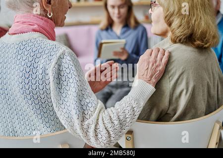 Vue arrière de la femme âgée pratiquant la façon de communiquer avec son ami à la psychothérapie Banque D'Images