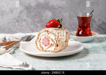 Gâteau aux fraises. Gâteau à la crème et aux fraises avec thé sur fond de pierre. gros plan Banque D'Images