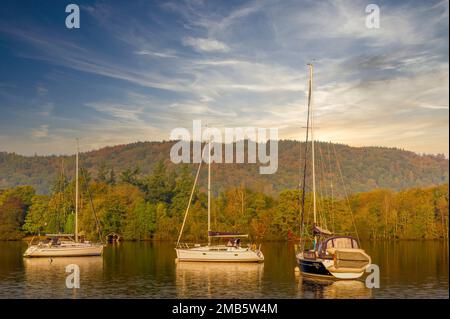 Trois yachts amarrés au coucher du soleil d'automne sur le lac Windermere, Cumbria, Royaume-Uni, Banque D'Images