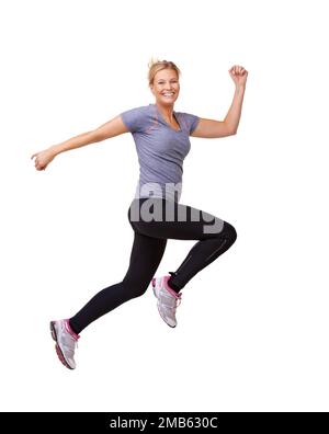 Un bond géant vers son objectif de remise en forme. Photo studio d'une belle jeune femme qui bonde dans l'air à travers le cadre isolé sur blanc. Banque D'Images