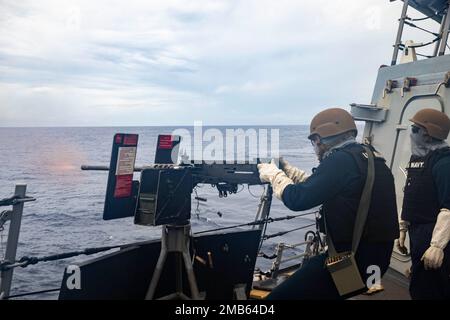 MER DE CHINE ORIENTALE (12 juin 2022) le compagnon 2nd de Gunner classe Adam Espindula, à droite, de Visalia, Californie, observe que Fire Controlman 2nd classe Garrett Hendricks, à gauche, de Lakeville, Minnesota, tire une mitrailleuse de calibre .50 lors d'une familiarisation avec le feu en direct à bord d'un destroyer de missile guidé de classe Arleigh Burke USS Dewey (DDG 105). Dewey est affecté au commandant de la Force opérationnelle 71/Escadrier Squadron (DESRON) 15, la plus grande force de surface déployée à l’avant de la Marine et la principale force de surface de la flotte américaine 7th. Banque D'Images