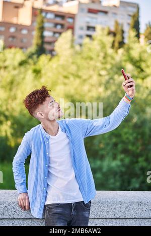 Jeune homme gay avec bracelet lgtb prenant un selfie. Concept de LGBT, relation et égalité des droits. Banque D'Images