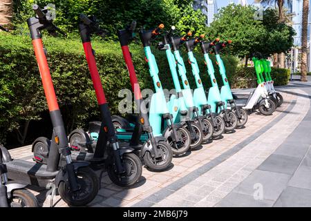 il y a beaucoup de scooters électriques dans la rangée sur le parking. Système de location de vélos de ville, kick-trottinettes publiques dans la rue Banque D'Images