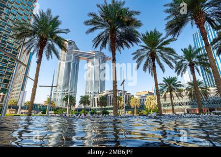 Dubai, Émirats Arabes Unis. belle vue sur les palmiers fontaine avec eau et hauts gratte-ciel. Banque D'Images